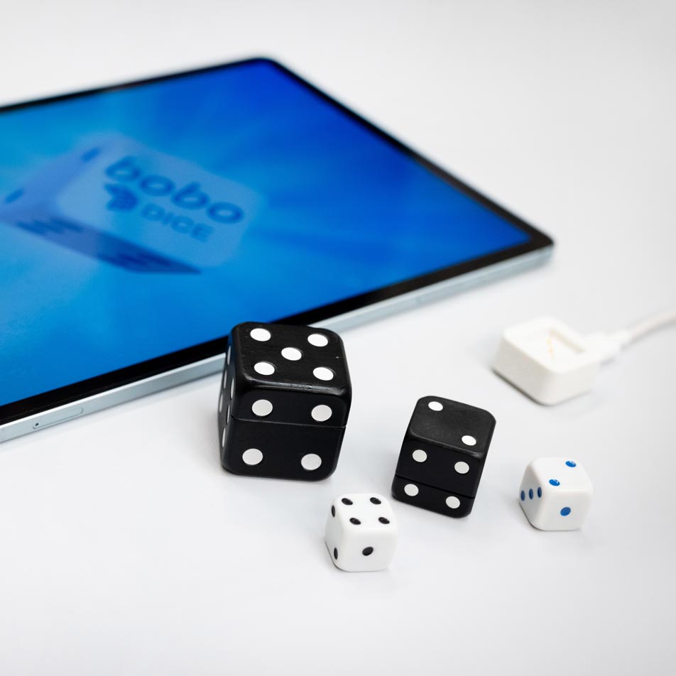 VAVO0054 Dice and tablet computer on a table: a set of dice and a modern tablet