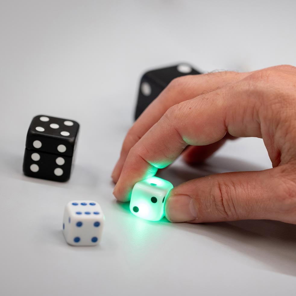 VAVO0237 Person holding green light above dice