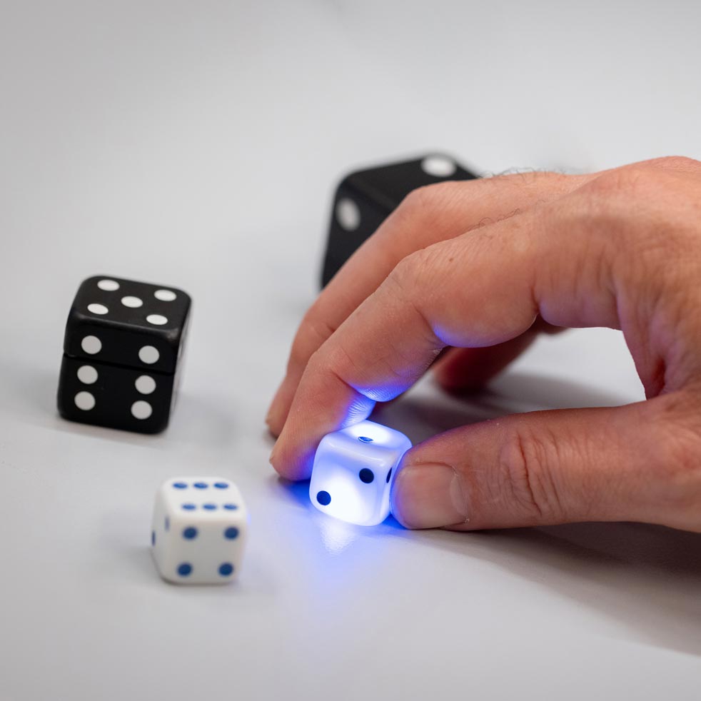 VAVO0244 Person holding a lighted dice emitting blue light