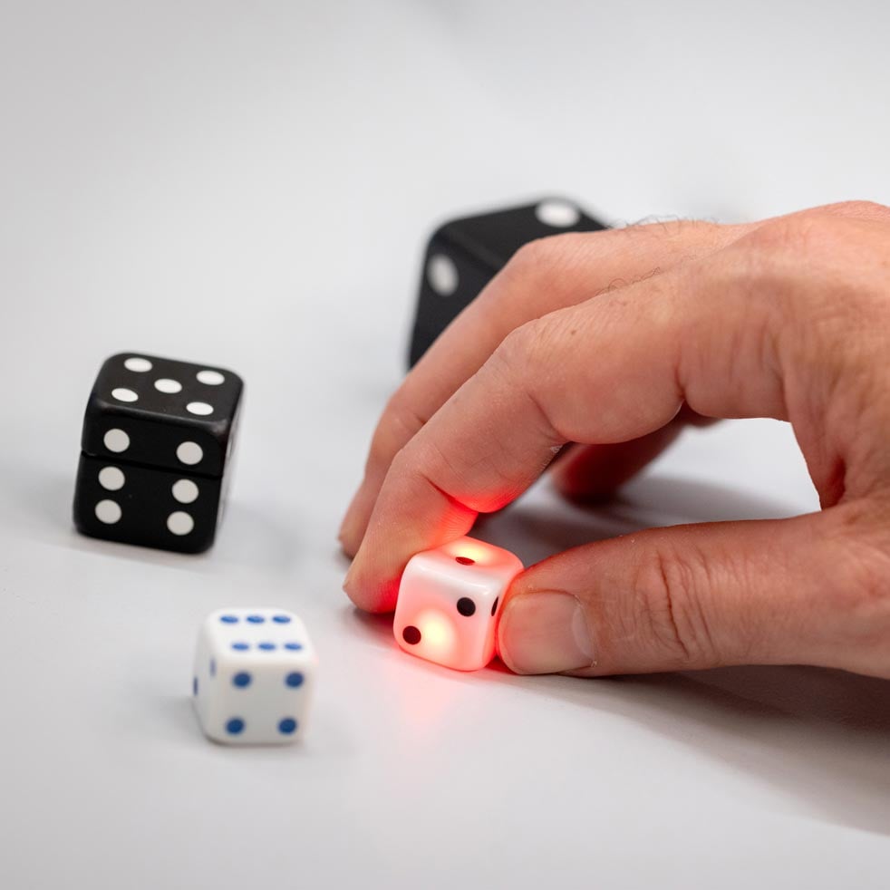 VAVO0250 A hand holding a glowing red dice