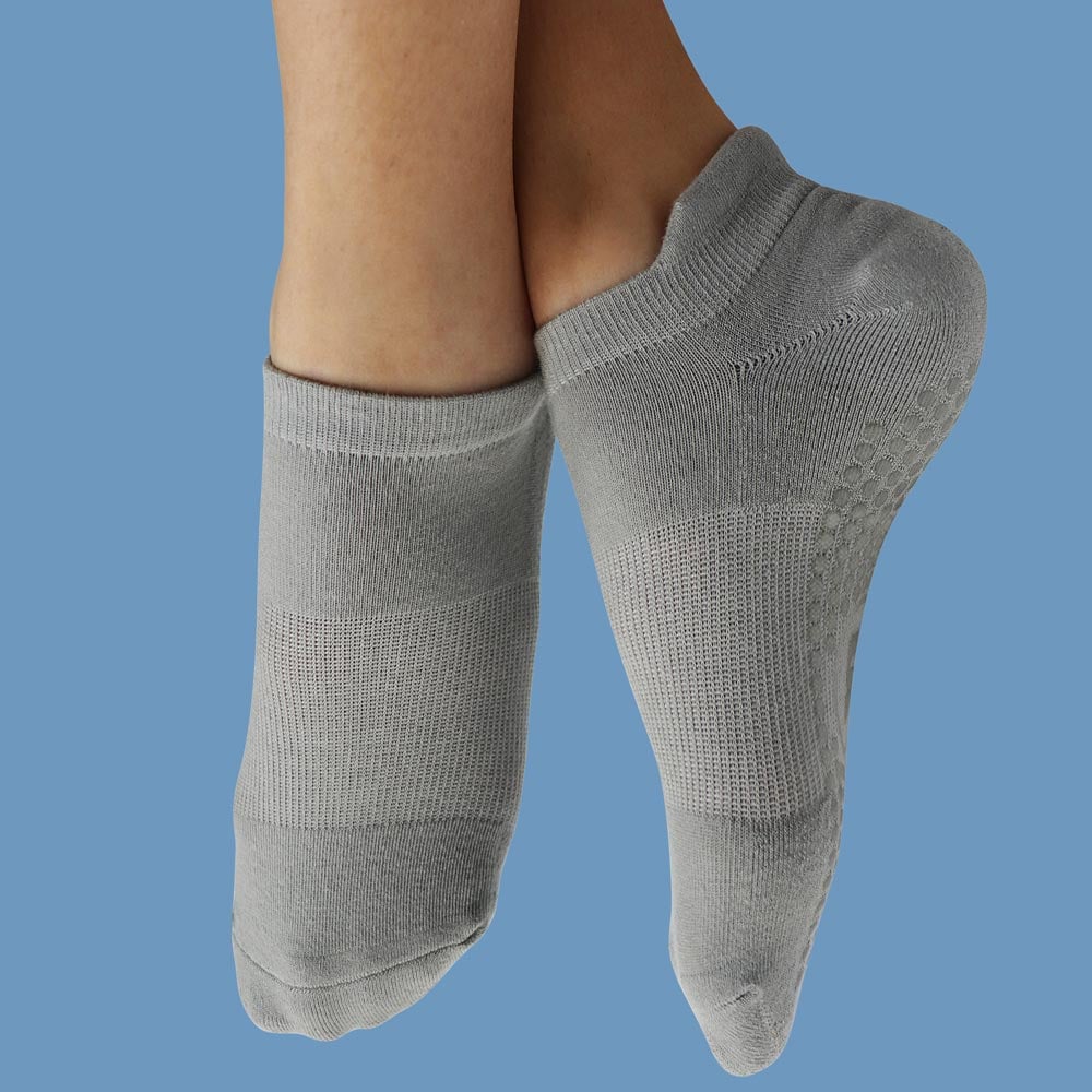 Light-Grey-Gallery-3 A pair of legs wearing grey socks stands out against a bright blue background.